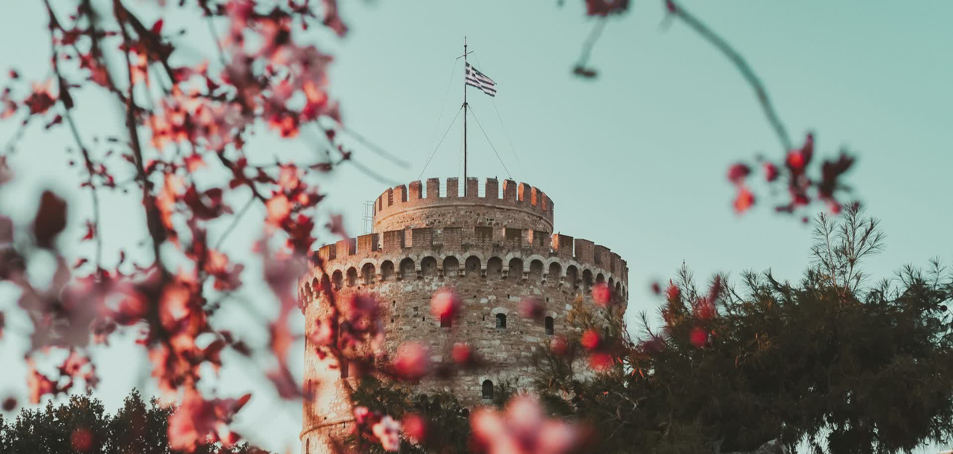 The White Tower framed through pink spring blossom — Thessaloniki at Easter